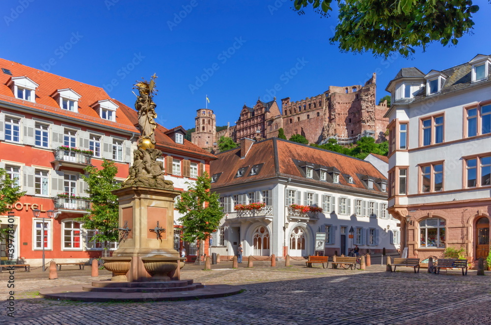 The Madonna statue in Kornmarkt square and castle in Heidelberg by day, Germany