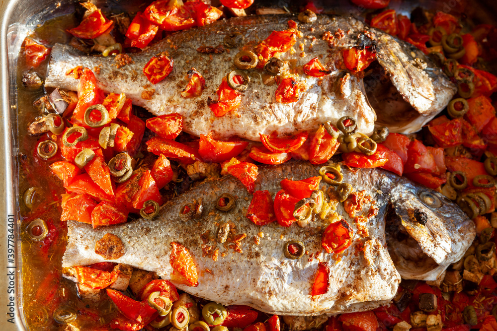 Zwei gegrillte Doraden mit Paprika und Oliven in der Draufsicht Zwei gegrillte Doraden mit Paprika und Oliven in der Draufsicht