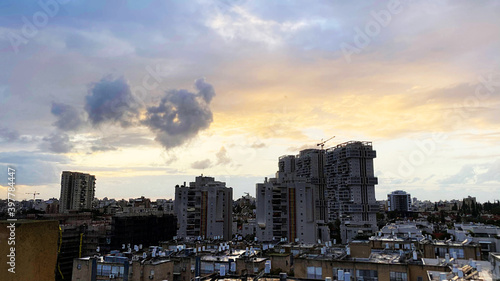 The roofs of city buildings against the background of the sunset