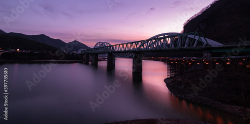 Beautiful and vibrant evening view of a bridge over the still waters of Namhan River in Danyang, South Korea. 