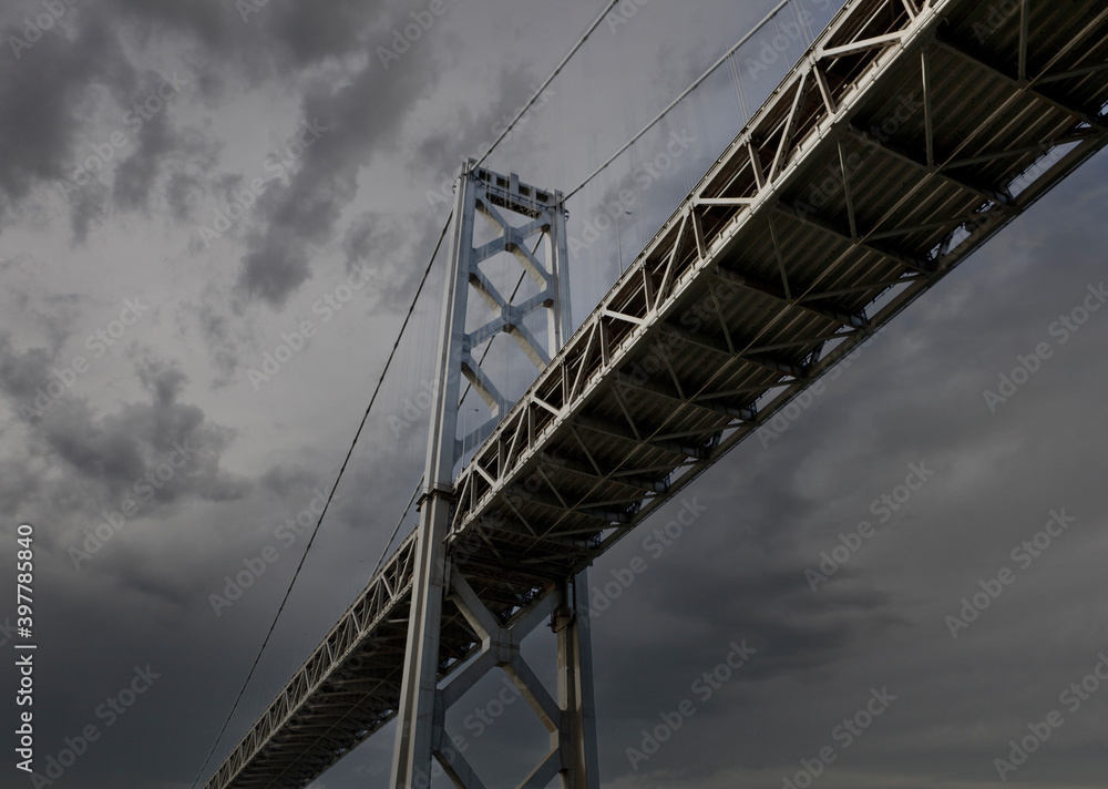 View below the San Francisco Oakland Bay Bridge with thunderstorm sky.