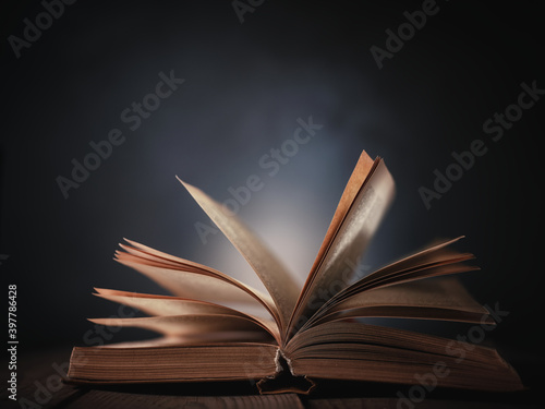 Open book on the table against the background of a dark wall