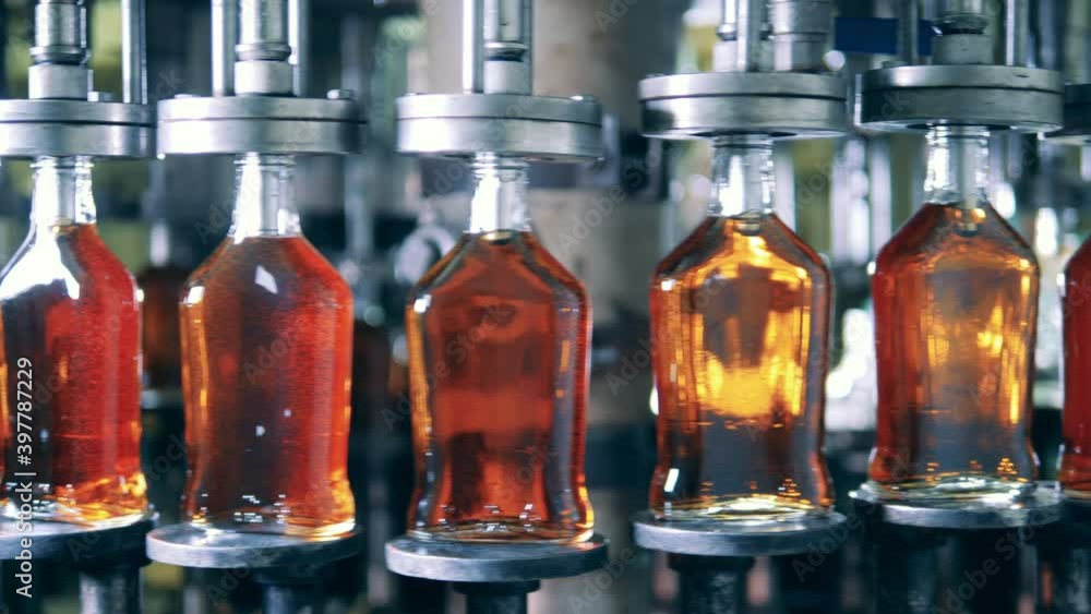 Spinning conveyor and glass bottles with fresh alcohol Spinning conveyor and glass bottles with fresh alcohol