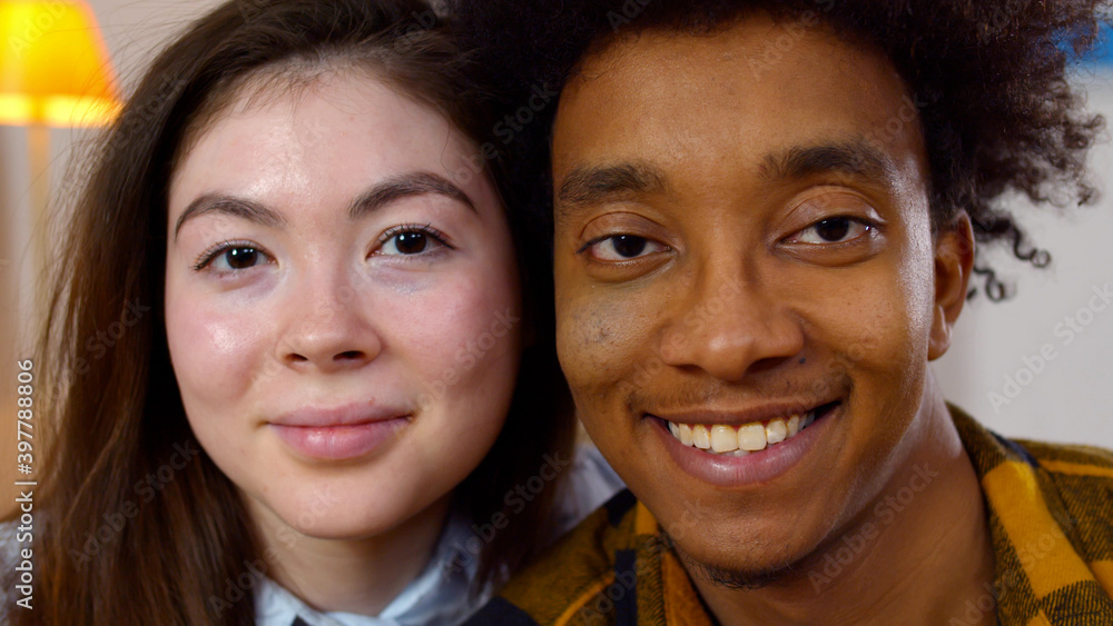 Close up portrait of happy multiethnic couple looking at camera Close up portrait of happy multiethnic couple looking at camera