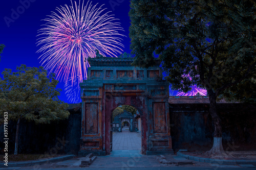 Celebratory fireworks for new year over Gate of the Forbidden imperial City at Hue, Vietnam during last night of year. Christmas atmosphere. 