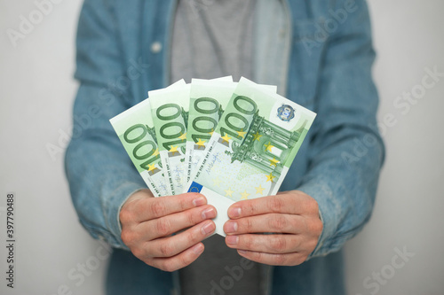 Businessman in blue shirt holds european euro money on white background, closeup. Money, earnings, crediting and finance.