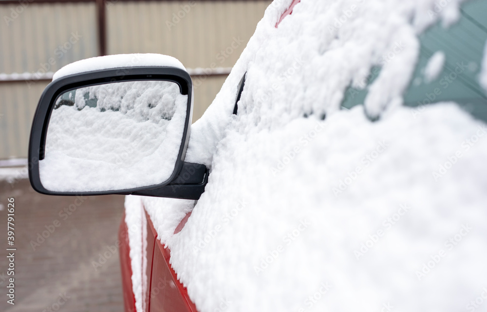 snow-covered left car mirror, natural background, first snow
