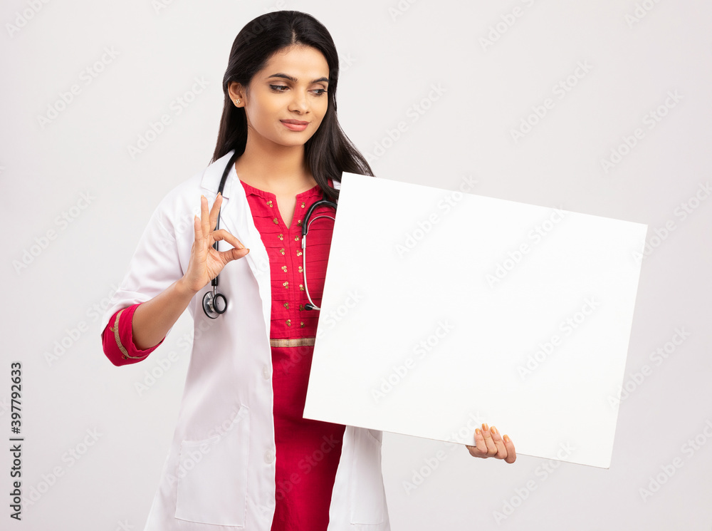 Female doctor holding a sign board on white Female doctor holding a sign board on white