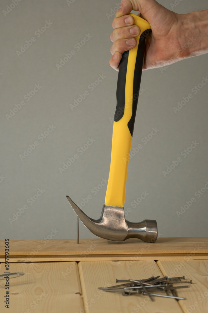 Pull out the nail with a claw hammer. The hammer is removing the nail