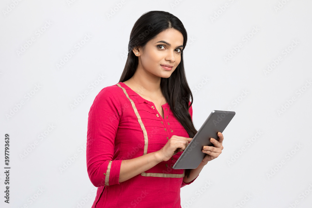 Pretty Indian young woman using digital tablet on white. Pretty Indian young woman using digital tablet on white.