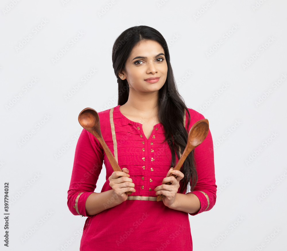 Cheerful Indian woman holding wooden skimmer on white. Cheerful Indian woman holding wooden skimmer on white.