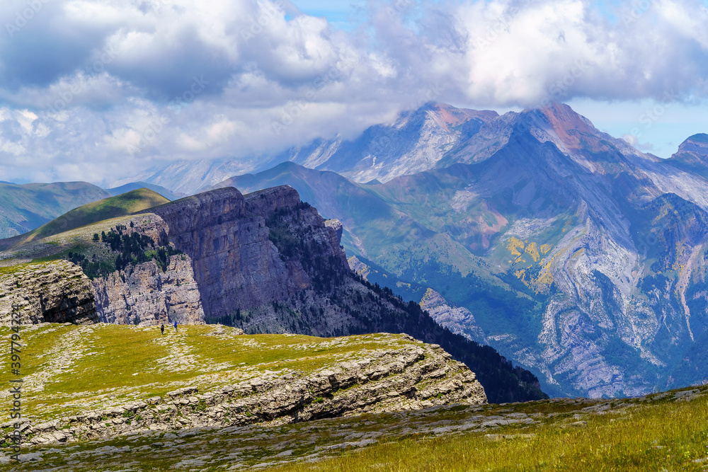 Obraz premium Green landscape in the Pyrenees of the Ordesa and Monte Perdido valley with mountains, rocks, forests and sky with clouds. Top aerial view. 