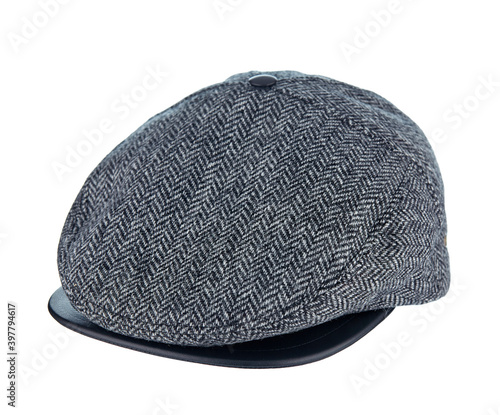 Beautiful tweed cap made of grey wool with a leather visor isolated on a white background. Sample of men's style.