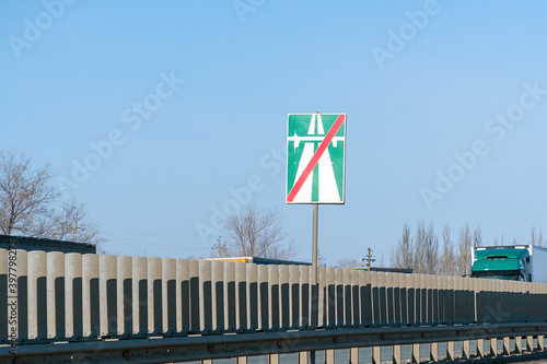 Road sign end of a motorway on a highway against a blue sky