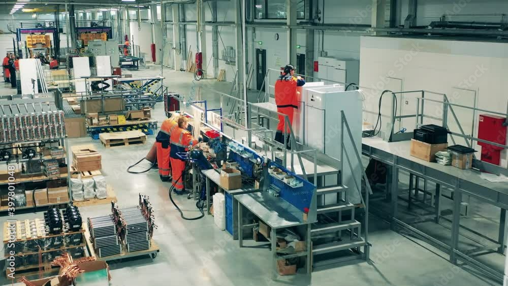 Factory workers are manufacturing refrigerators. Workers at a factory production line.