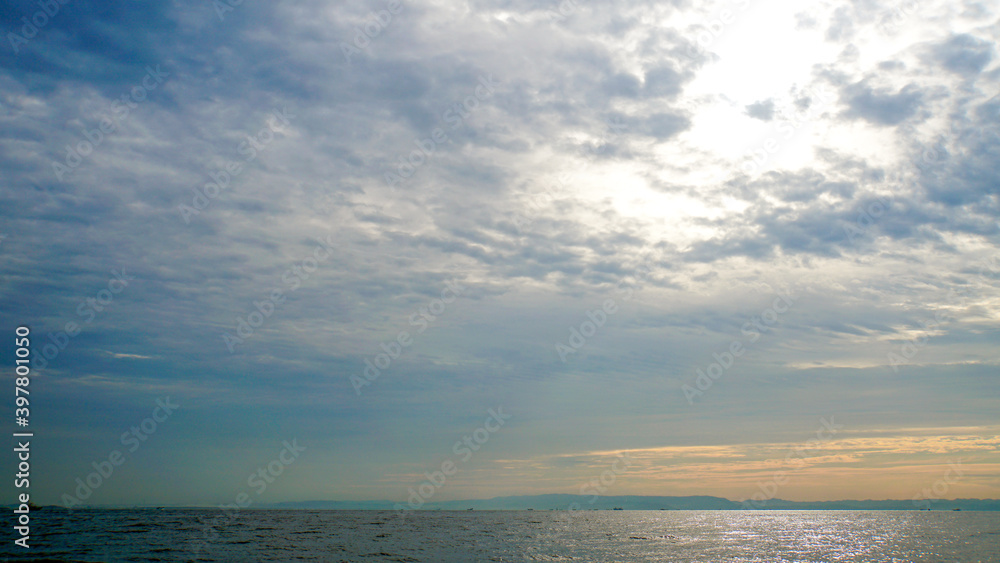 雲の裏に輝く太陽と一面に広がる相模湾の海原