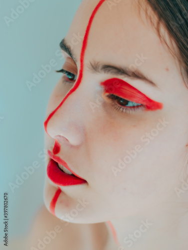 portrait of girl with flamboyant makeup, eye-catching eyes and piercing look, painted red