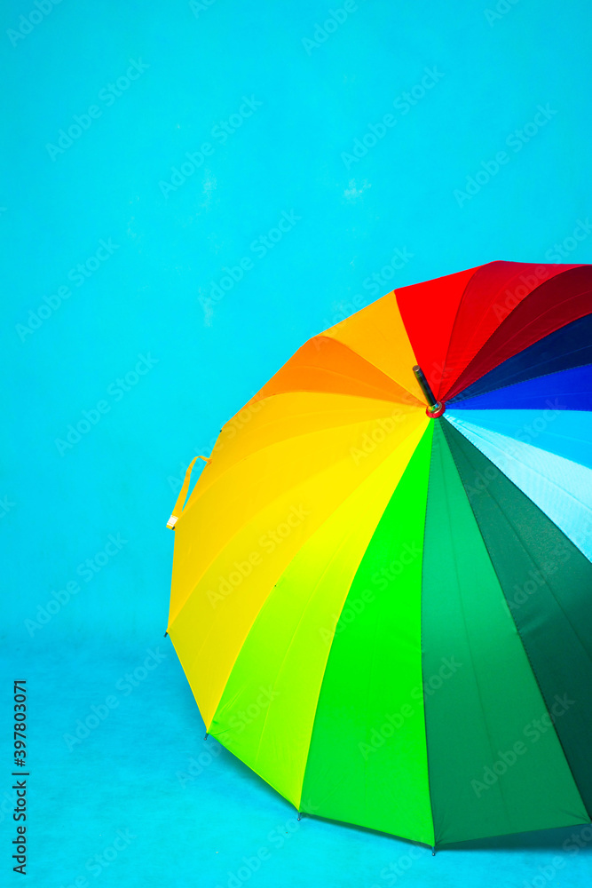 Colored umbrella on a blue background . Bright umbrella. Copy space.