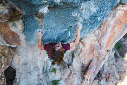 A young athlete climbs a rock