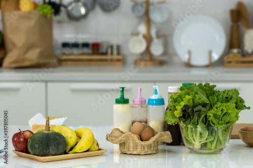 Fruits, vegetables and eggs on the white table in the kitchen.