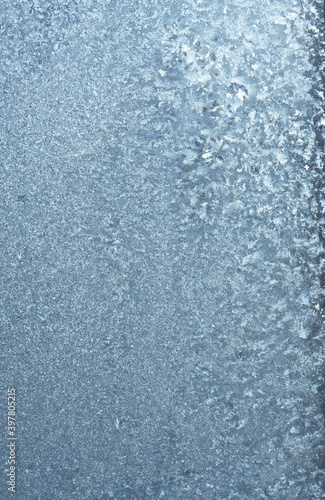 Vertical image of a winter background on a transparent glass window with a frozen texture. Abstract texture background  vertical photo  copy space for your design or text