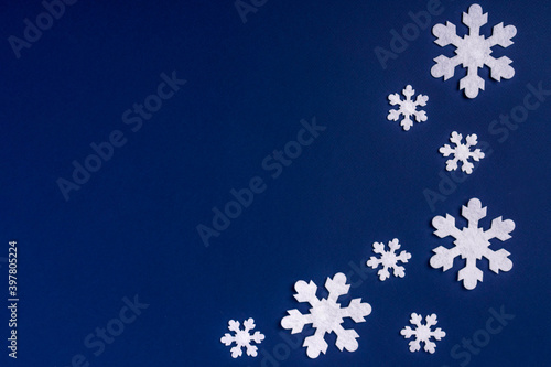Winter Christmas composition, paper snowflakes lie on a blue background, space for text