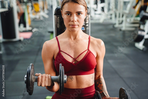 Concentrated serious young woman fitness coach