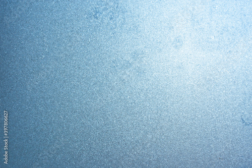 Winter background on a transparent glass of a window with a frozen texture. Abstract texture background, horizontal image, copy space for your design or text