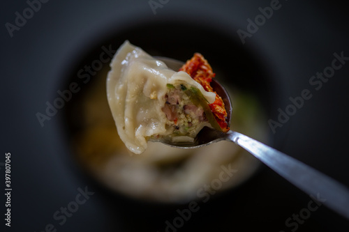 Korean Squid Dumpling Soup which is called MandutGuk with Kimchi photo