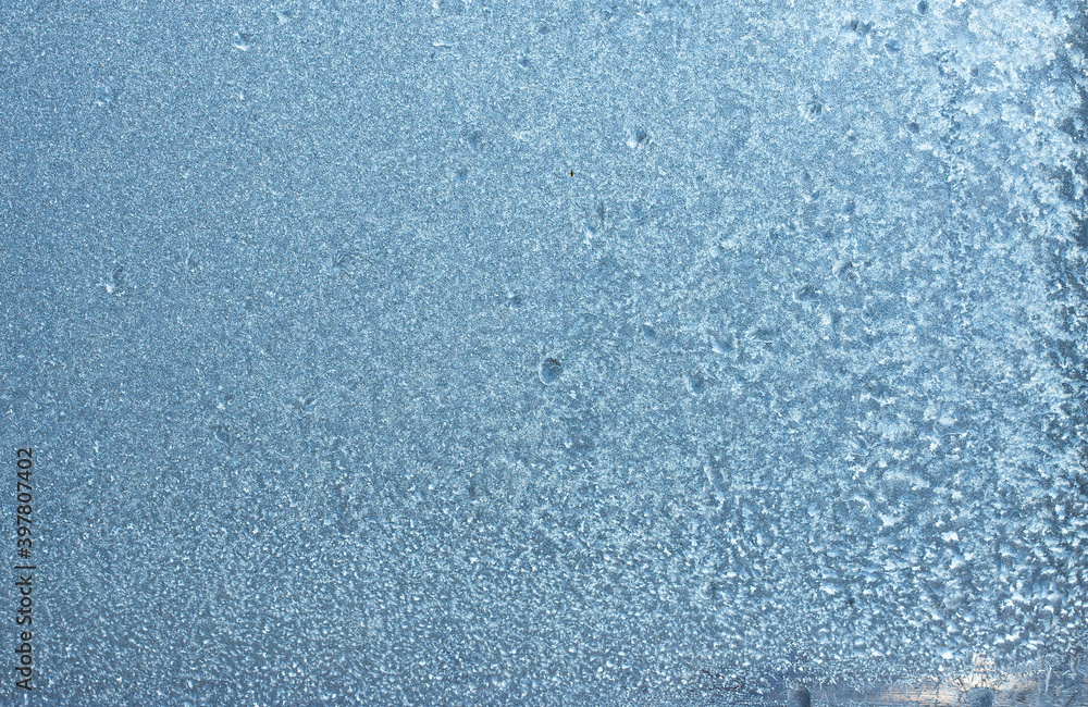 Obraz premium Completely frozen window on transparent glass. Clean background. Extreme low temperatures in winter. Water vapor condenses on cold window glass and freezes