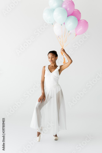 graceful african american ballerina with balloons isolated on white