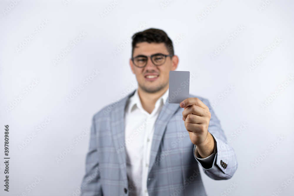 Business young man wearing a casual shirt over white background holding white card