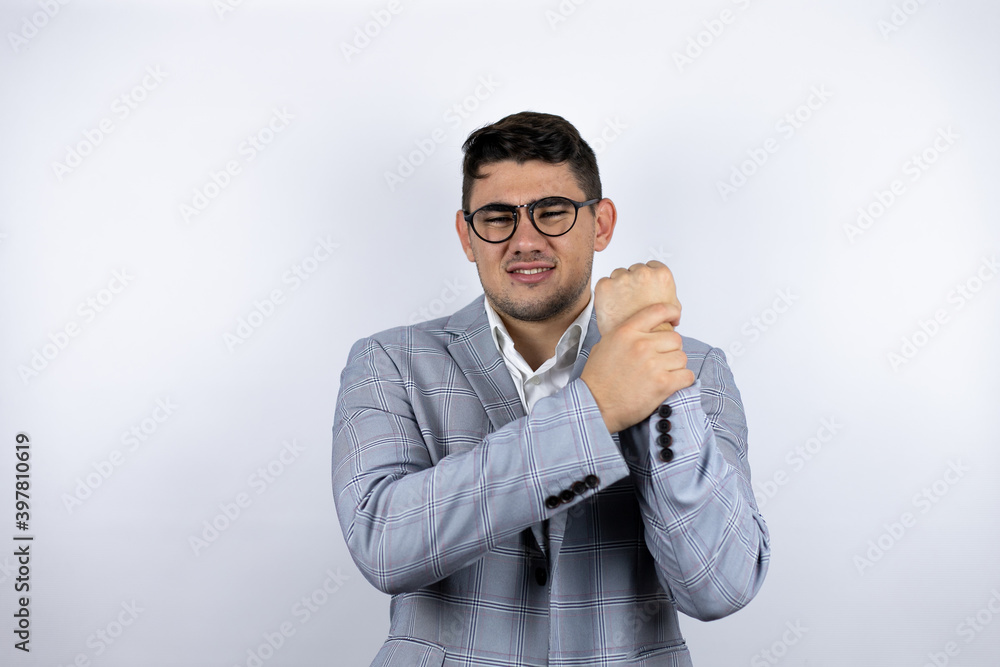 Business young man wearing a casual shirt over white background suffering pain on hands and fingers, arthritis inflammation Business young man wearing a casual shirt over white background suffering pain on hands and fingers, arthritis inflammation