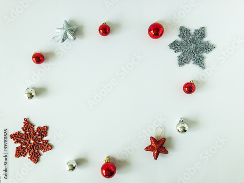 Arrangement of christmas ball ornaments, stars and snowflakes on an isolated white surface with copy space, top view