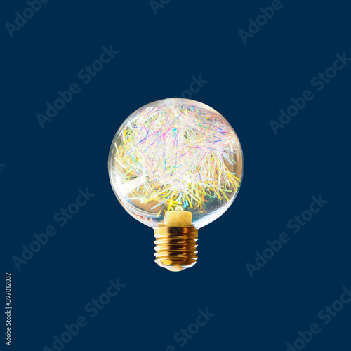 Christmas glowing bulb with garland isolated on blue background. Interior decoration for new year  holiday