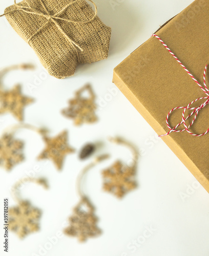Christmas present boxes with wooden christmas ornaments and a pine cone on an isolated white surface, top view