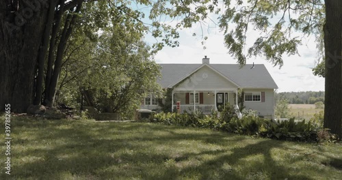 Gorgeous backyard garden with a rope swing with a white house in the distance. photo