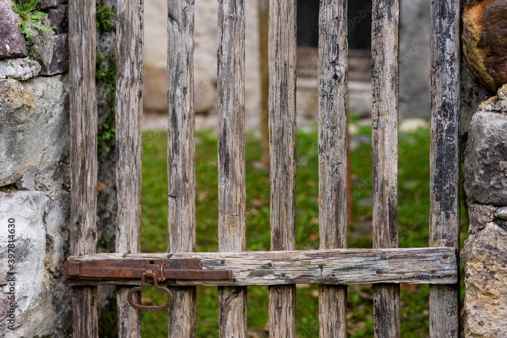 Detail of old wooden gate with metal lock. Detail vintage object in the countryside.