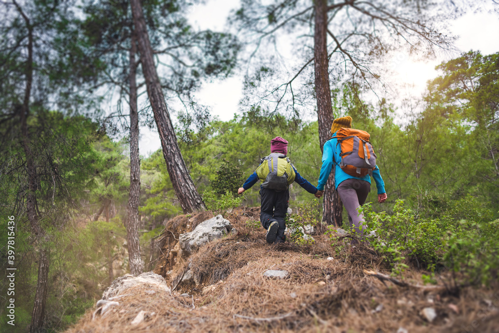 Naklejka premium A child with his mother on a hike to the mountains