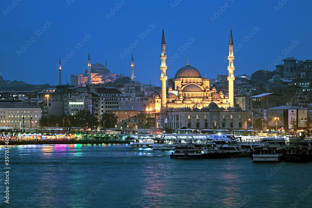 Fototapeta premium Evening view of Yeni Mosque, Hagia Sophia, Eminonu pier and Galata Bridge in Istanbul, Turkey