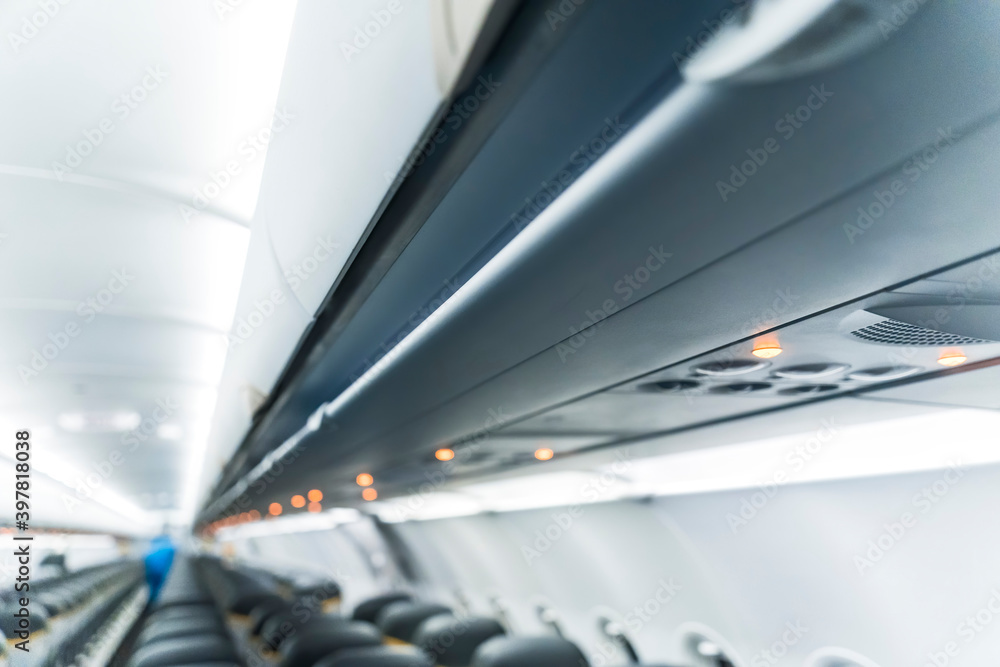 Interior of airplane without passengers on seats. Aircraft's corridor interior in modern tones. Selective focus.