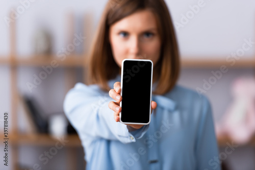 Smartphone with blank screen in hand of blurred psychologist on background