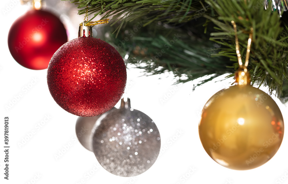 Decorative glass white, golden, and red glittering ball ornaments on Christmas tree. Some balls and tree are blurred. Isolated on white background. Winter holiday decoration concept