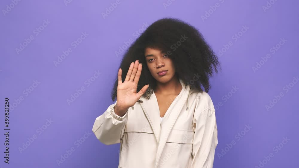 Young african american curly woman holding hands in pray near mouth, feels confident Young african american curly woman holding hands in pray near mouth, feels confident