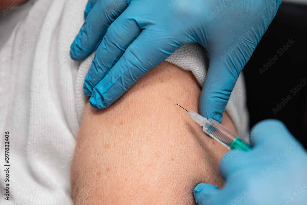 close up of an elderly adult woman, getting a vaccination close up of an elderly adult woman, getting a vaccination