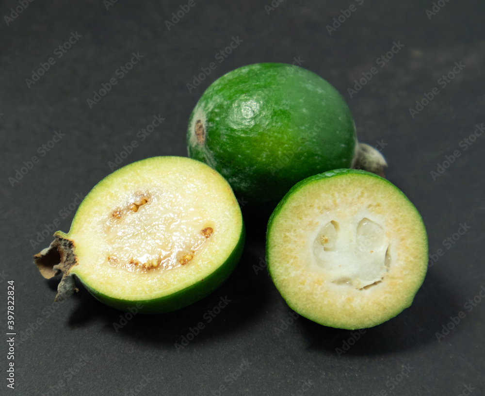 Feijoa fruits on black background. Tropical ripe feijoa fruits. Feijoa fruits on black background. Tropical ripe feijoa fruits.