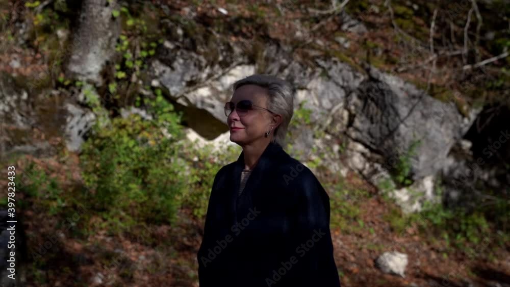 luxury middle-aged woman is visiting natural landmarks, blonde lady is walking alone luxury middle-aged woman is visiting natural landmarks, blonde lady is walking alone