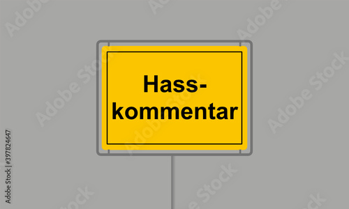 Gelbes Ortsschild mit dem Wort Hasskommentar vor grauem Hintergrund