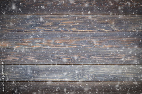Brown wooden background made of boards with snowflakes. The concept of the winter mood