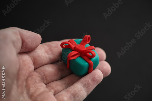 Man holding a plasticine gift box in his hand. Shallow depth of field.